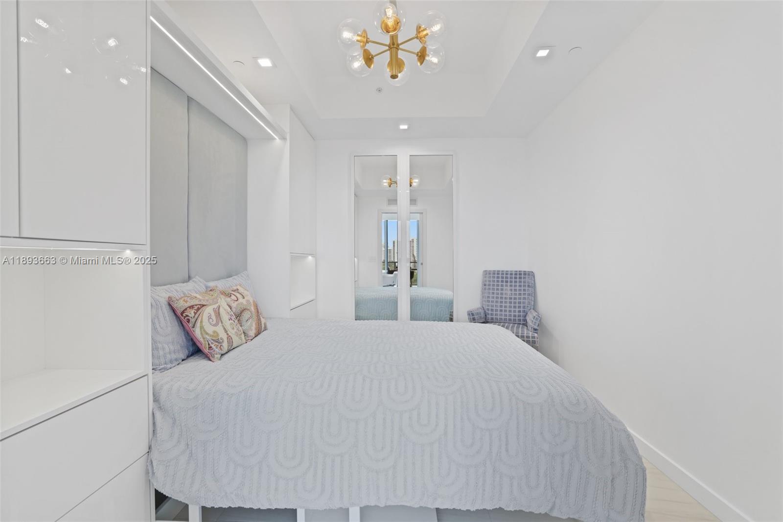 2200 North Ocean Boulevard, Unit N504 Fort Lauderdale, FL 33305 - Photo 23 of 43 a bedroom with a bed and a chandelier