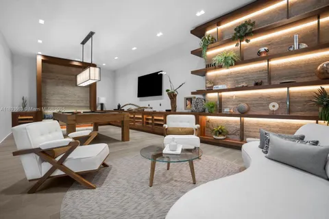 a living room with furniture kitchen view and a chandelier