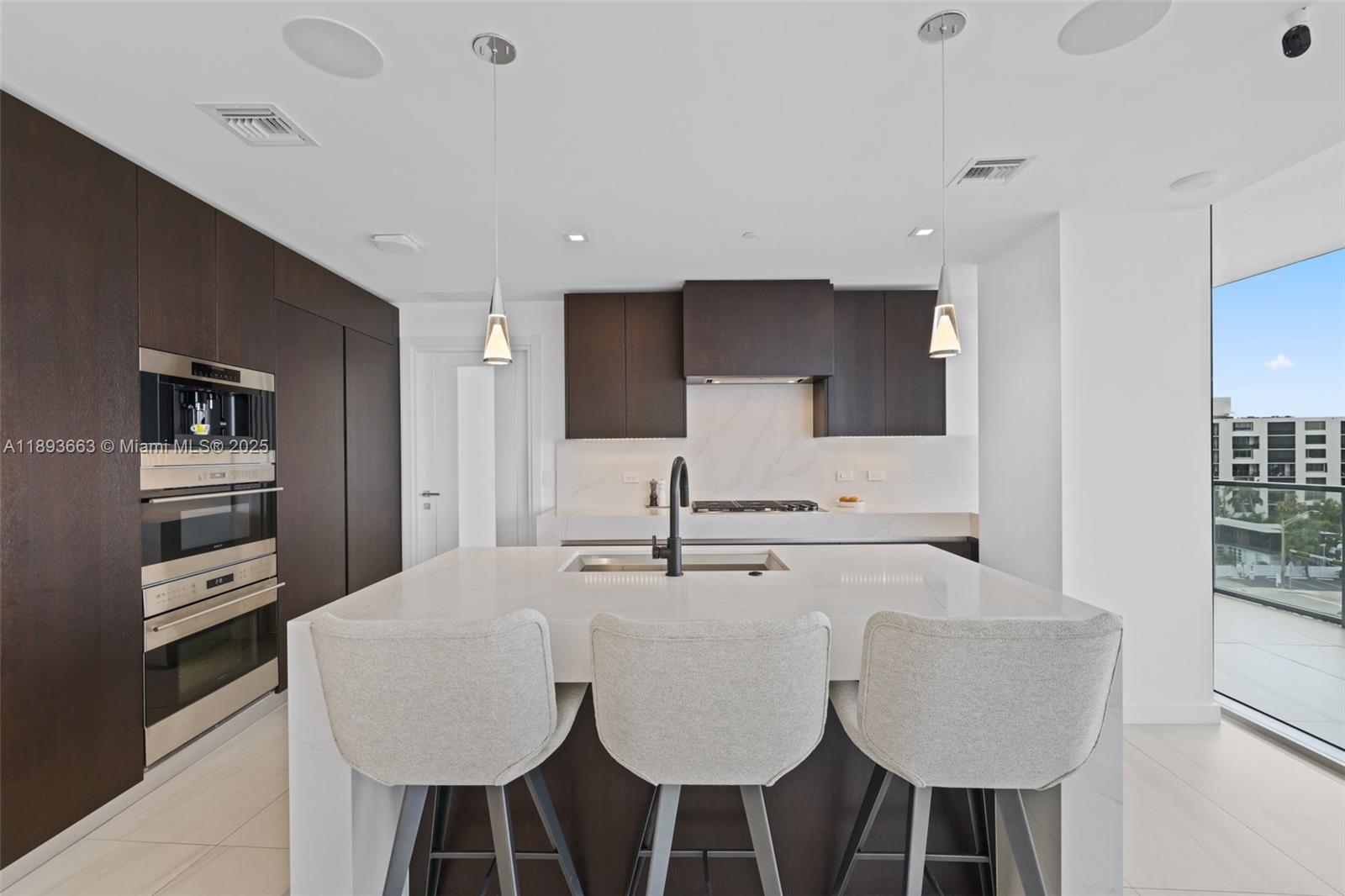 2200 North Ocean Boulevard, Unit N504 Fort Lauderdale, FL 33305 - Photo 7 of 43 a kitchen with kitchen island granite countertop a sink cabinets and refrigerator