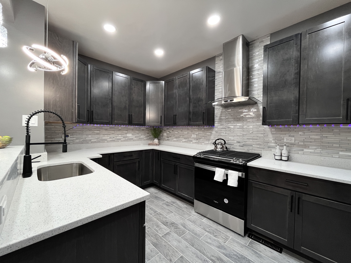 1111 North Keystone Avenue Chicago, IL 60651 - Photo 2 of 34 a kitchen with a sink dishwasher a stove and a refrigerator with wooden floor