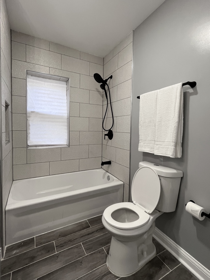 1111 North Keystone Avenue Chicago, IL 60651 - Photo 8 of 34 a bathroom with a toilet and a bathtub
