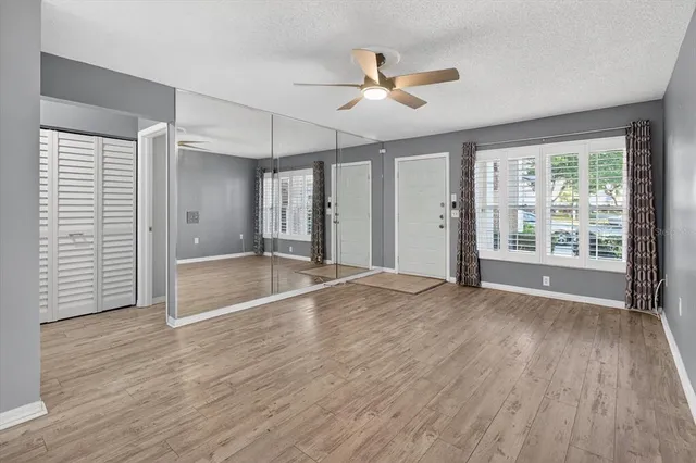 a view of a kitchen with wooden floor and a ceiling fan
