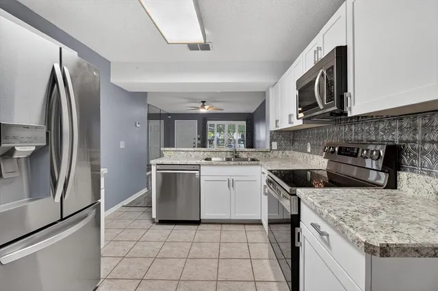 a kitchen with stainless steel appliances granite countertop a refrigerator and a stove
