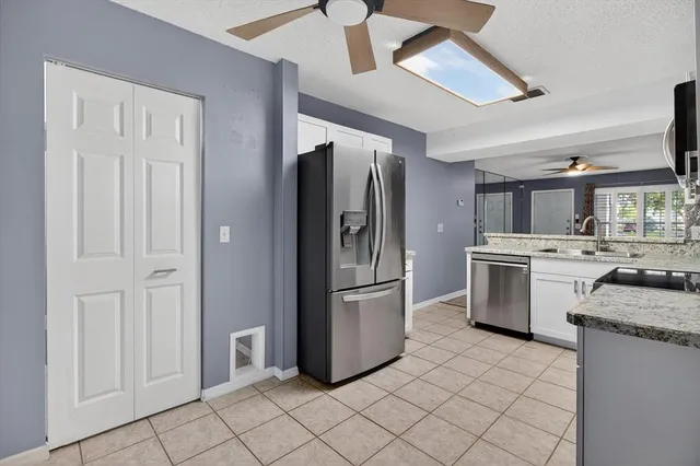 a kitchen with stainless steel appliances granite countertop a refrigerator a sink and a stove