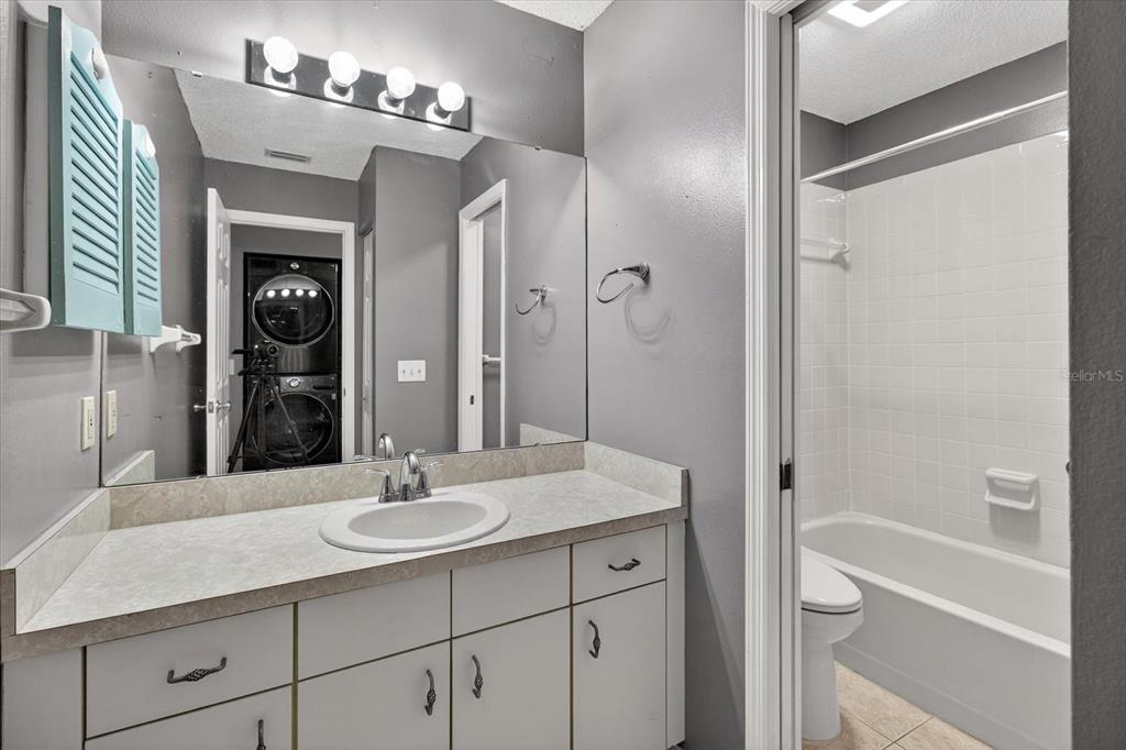 7802 Hardwick Drive, Unit 1116 New Port Richey, FL 34653 - Photo 33 of 73 a bathroom with a granite countertop sink a mirror and a bathtub
