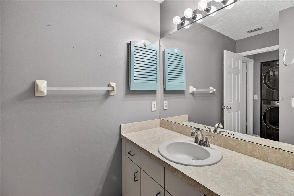 7802 Hardwick Drive, Unit 1116 New Port Richey, FL 34653 - Photo 34 of 73 a bathroom with a granite countertop sink a mirror and vanity