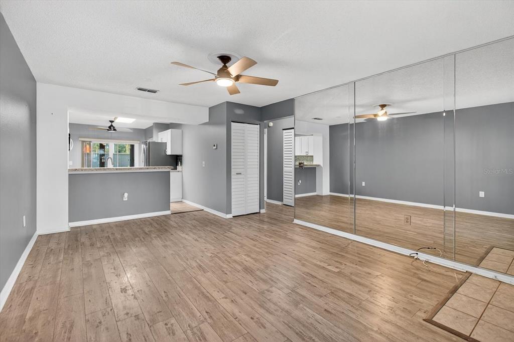 7802 Hardwick Drive, Unit 1116 New Port Richey, FL 34653 - Photo 6 of 73 a view of a livingroom with a kitchen space wooden floor and a ceiling fan