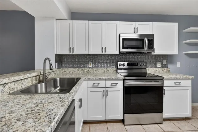 a kitchen with white cabinets stainless steel appliances and a sink