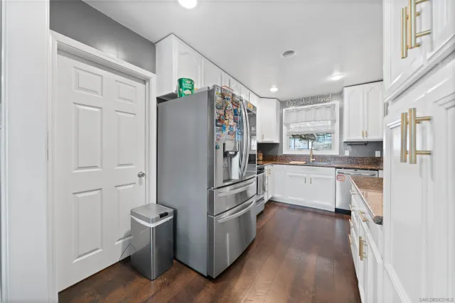 a kitchen with white cabinets and stainless steel appliances