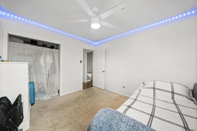 a bedroom with a bed and a refrigerator