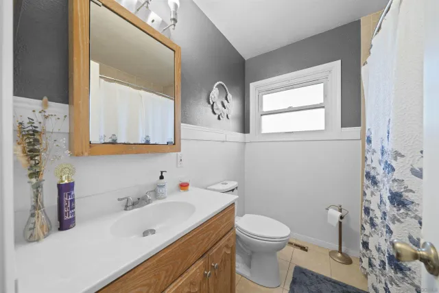 a bathroom with a toilet sink vanity and mirror