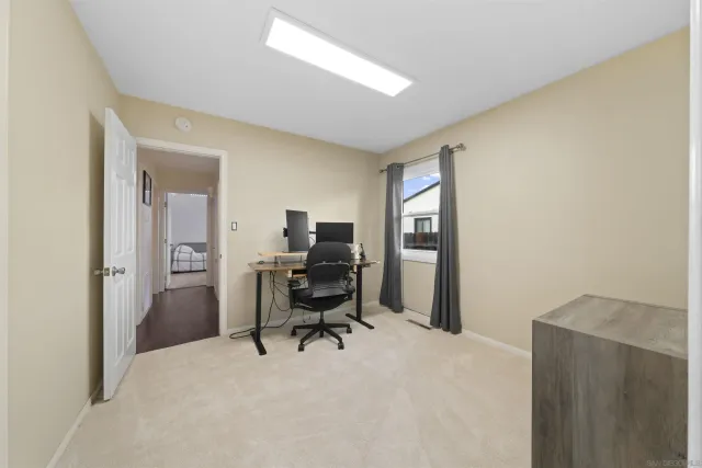 a view of a workspace with furniture and a window