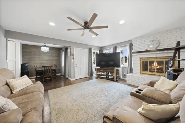 a living room with furniture and a flat screen tv with kitchen view