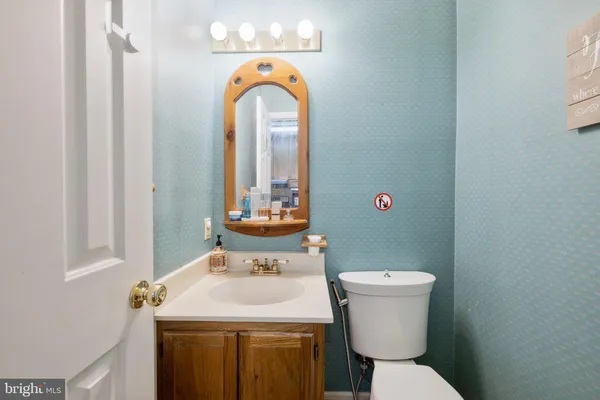 a bathroom with a sink a toilet and a mirror