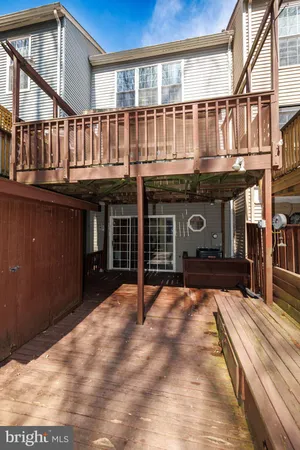 a view of a house with a barbeque and wooden stairs