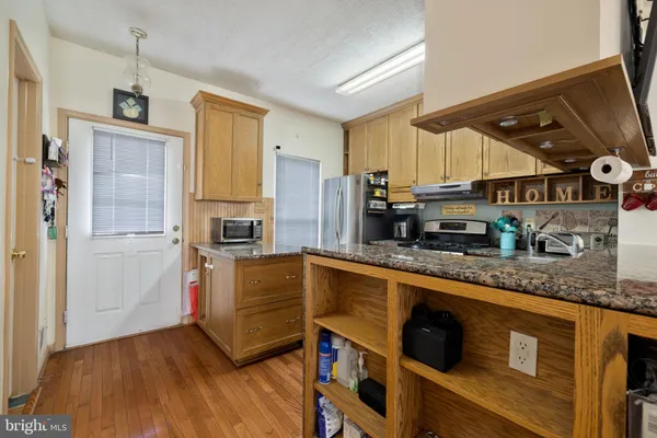 a kitchen with stainless steel appliances granite countertop a sink a stove and refrigerator