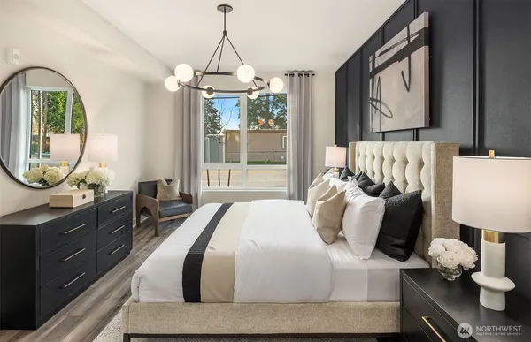 a bedroom with a bed mirror on desk and a window