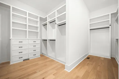 an empty room with windows and ceiling fan