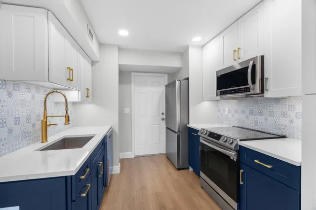 a kitchen with stainless steel appliances a stove a sink and a microwave