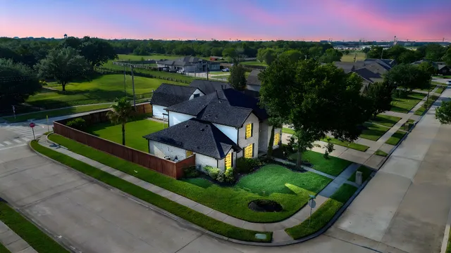 an aerial view of a house with a garden and lake view