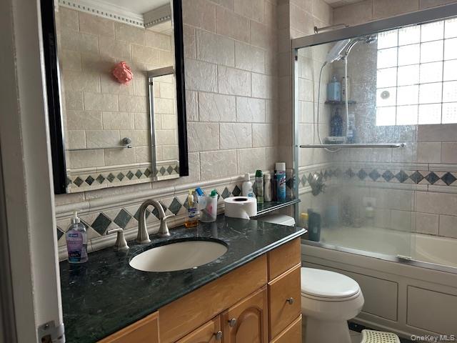22-05 80th Street Queens, NY 11370 - Photo 13 of 17 a bathroom with a granite countertop sink a toilet a mirror and bathtub