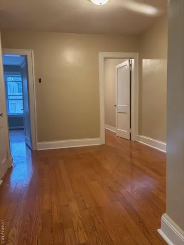 an empty room with wooden floor and closet
