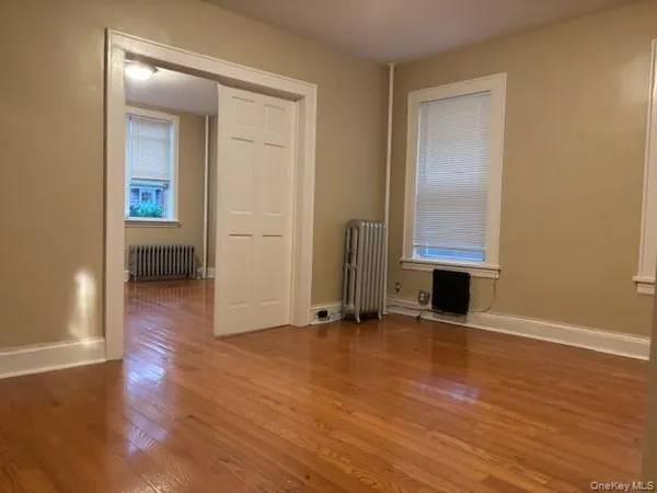 a view of a room with wooden floor and windows