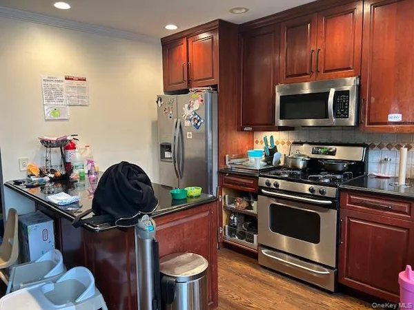 a kitchen with a sink a stove cabinets and a wooden floor