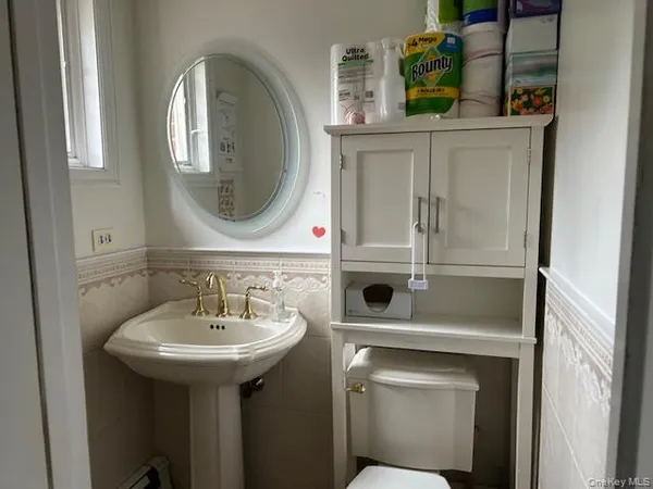 a bathroom with a toilet sink and mirror