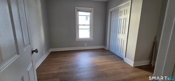 a view of a room with wooden floor and window