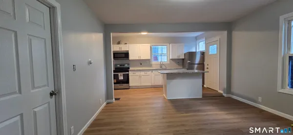 a kitchen with stainless steel appliances granite countertop a refrigerator a stove and a sink