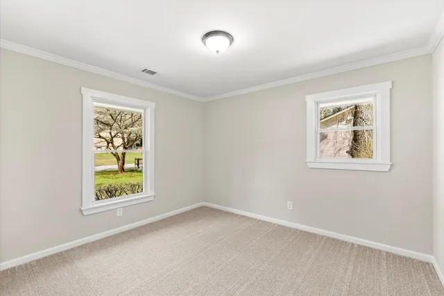a view of an empty room with a window and a ceiling fan