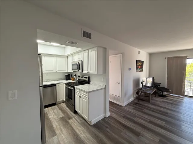 a kitchen with stainless steel appliances granite countertop a refrigerator sink and stove