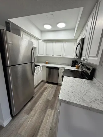 a view of a hallway with wooden floor and stairs