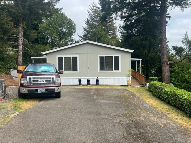 1050 North Cedar Point Road, Unit C09 Coquille, OR 97423 - Photo 2 of 38 a car parked in front of a house with trees