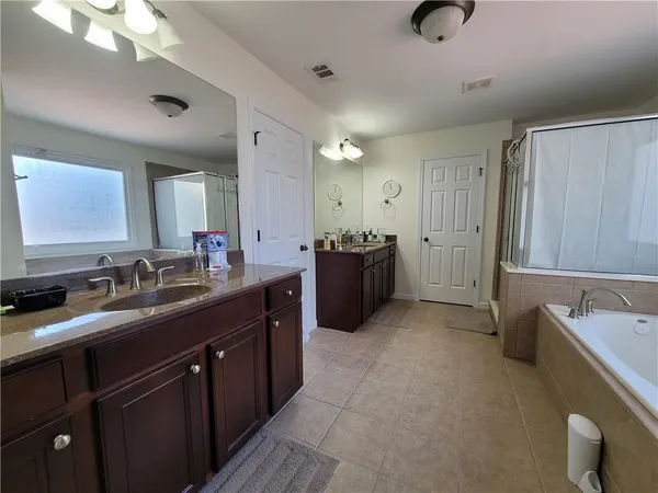 a bathroom with a granite countertop sink double vanity and a mirror
