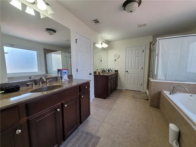 a bathroom with a granite countertop sink double vanity and a mirror