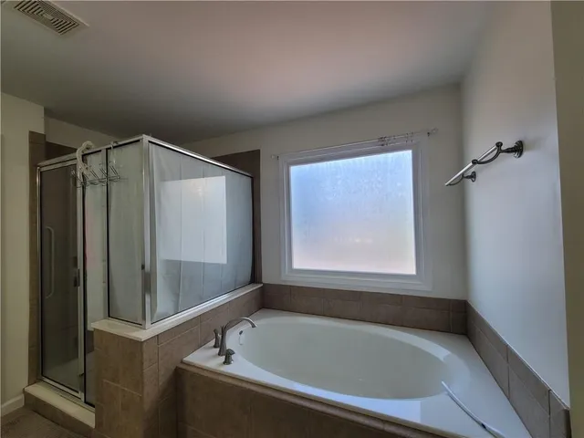 a bathroom with a tub and a shower