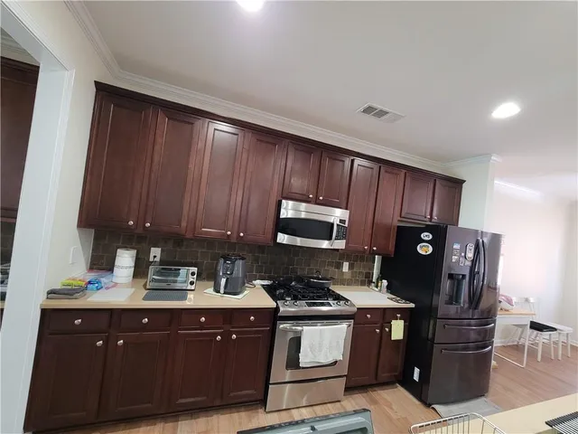 a kitchen with stainless steel appliances granite countertop a refrigerator a stove a sink and a microwave