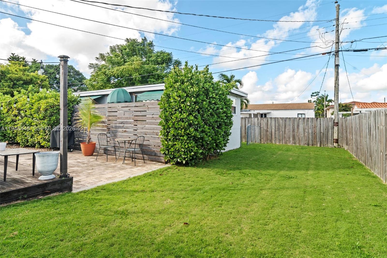 3151 Southwest 20th Street, Unit 1 Miami, FL 33145 - Photo 8 of 18 a view of a backyard with plants and large trees with wooden fence