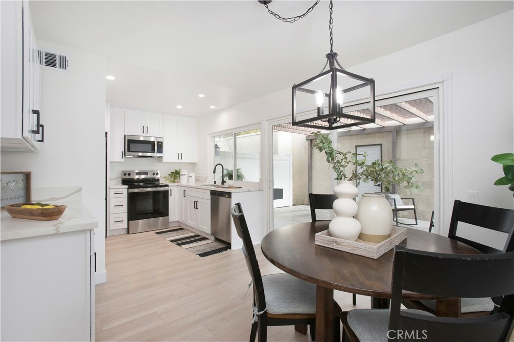 519 Breezewood Court Brea, CA 92821 - Photo 2 of 30 a kitchen with stainless steel appliances granite countertop a dining table chairs stove and refrigerator