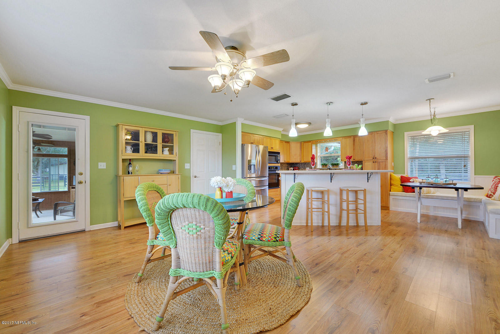 5280 Truman Pacetti Road St. Augustine, FL 32092 - Photo 13 of 34 a dining room with wooden floor a chandelier a glass table and chairs