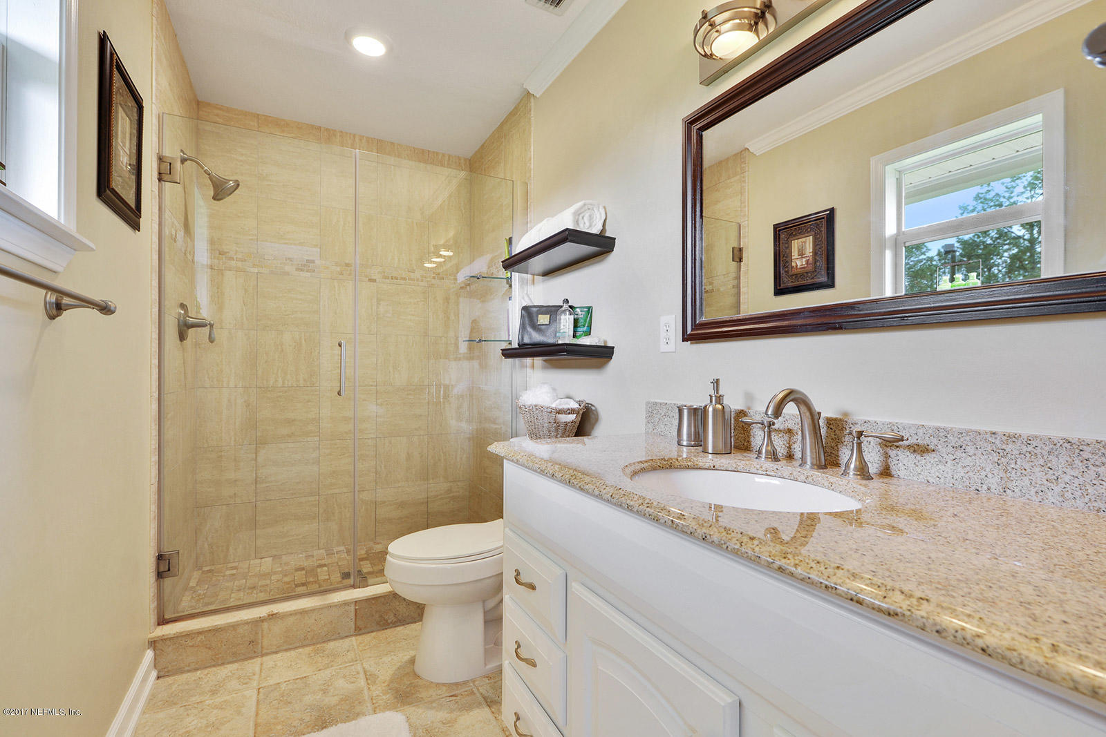 5280 Truman Pacetti Road St. Augustine, FL 32092 - Photo 22 of 34 a bathroom with a granite countertop sink a toilet a mirror and shower