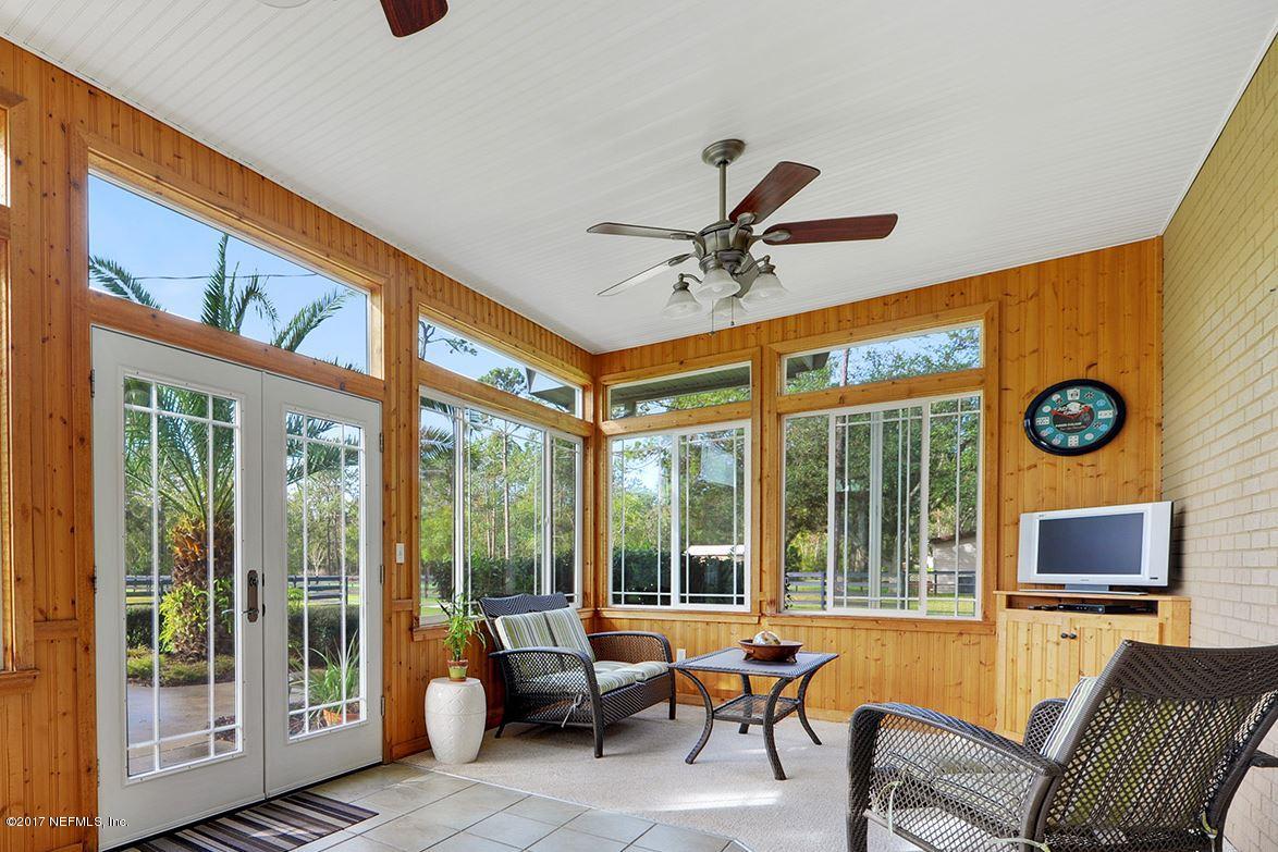 5280 Truman Pacetti Road St. Augustine, FL 32092 - Photo 3 of 34 a living room with furniture a floor to ceiling window and a flat screen tv