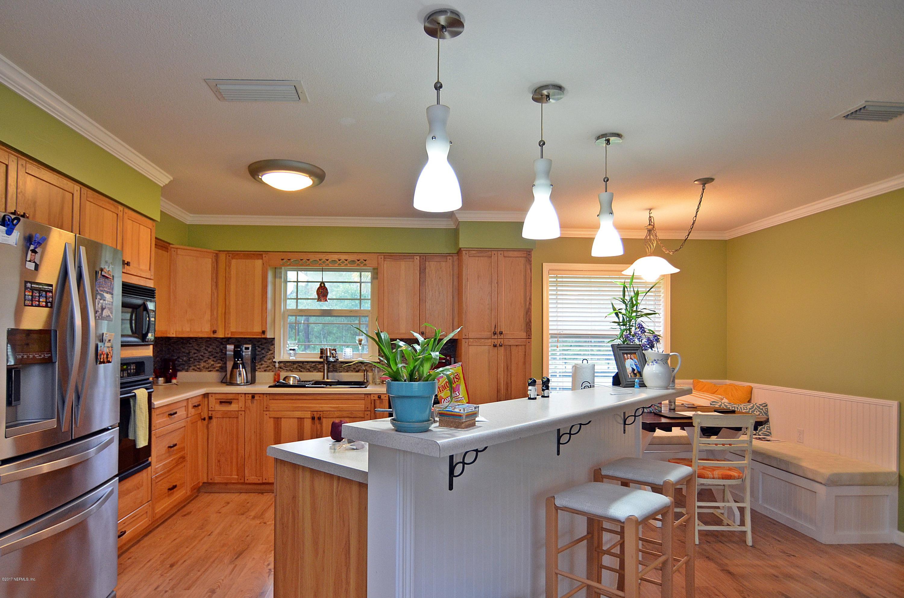 5280 Truman Pacetti Road St. Augustine, FL 32092 - Photo 6 of 34 a kitchen with a table chairs stove and cabinets