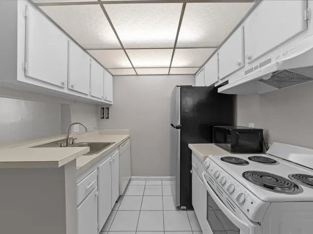 a kitchen that has a sink a stove and a refrigerator