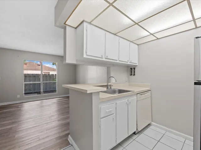 a kitchen with stainless steel appliances granite countertop a sink and cabinets with wooden floor