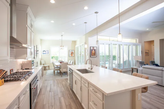 a kitchen with counter top space a sink stove and wooden floor