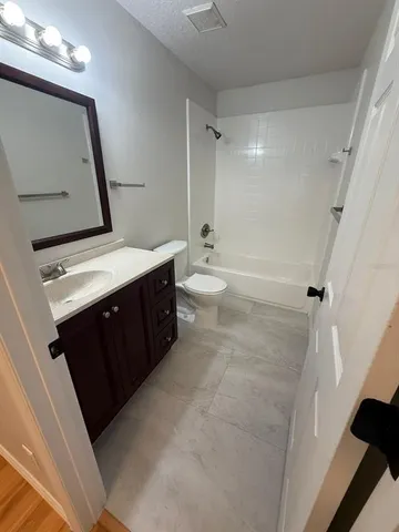 a bathroom with a double vanity sink toilet mirror and tub