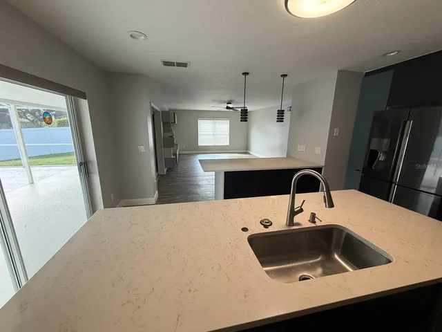a kitchen with a sink a refrigerator and cabinets